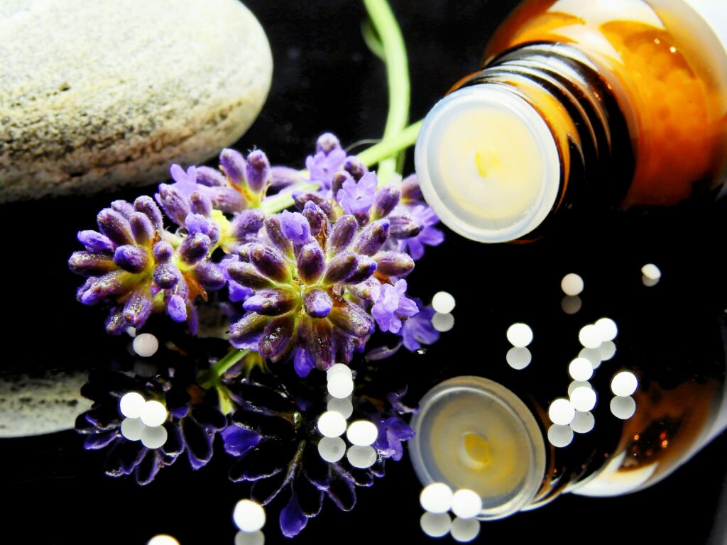 Home Pills 2 Lavender flowers with herbal homeopathy on a reflective surface, ideal for natural therapy themes.